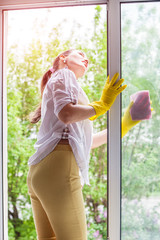 Cleaning concept. Young woman washing window, close up