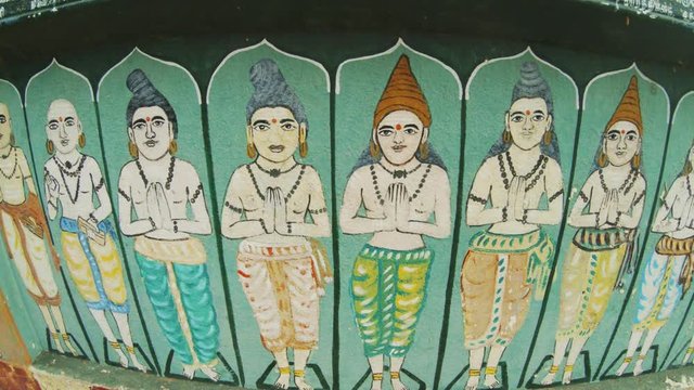 Indian saints painted on a wall hands folded in namaste