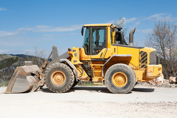 Heavy yellow wheel loader excavator, close-up.