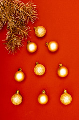 Creative vertical pattern with golden Christmas tree branches and multiple golden baubles. Concept