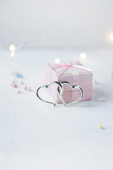 Gift box, decorative hearts and lights on a light background. Valentine's day concept
