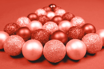 Christmas baubles on coral background.