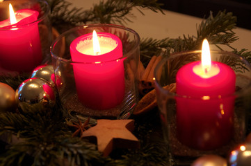 Weihnachtskerzendekoration mit brennenden Kerzen im Advent erleuchtet die Zeit bis Heiligabend im Kerzenschein