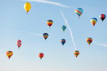 Multi colored hot air balloon flying over blue sky