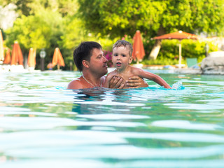 Father and child swimming in the pool