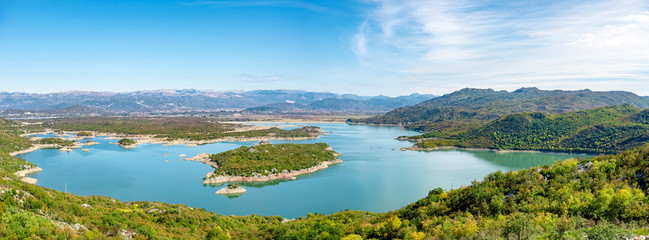 Panorama of lake with mountain with island, salt lake in Montenegro in calm waters of lake