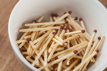 match sticks in the ceramic bowl on the wooden table