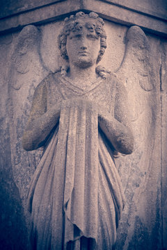 Antique statue of angel. Dramatic unusual scene. Retro filter and vintage style.