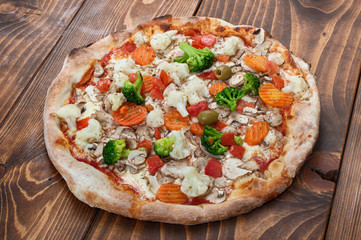Pizza vegetariana on wooden background, side view