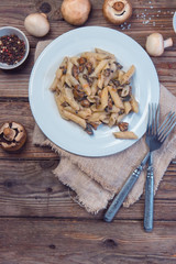 Delicious Italian penne pasta with fried creamy mushrooms champignon . Healthy concept.Top view