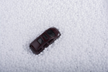 Model car on white polystyrene foam balls