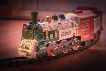 Old- fashioned Christmas train on rails as decoration under the Christmas tree