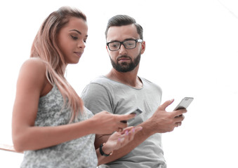young couple looking at the screens of their smartphones