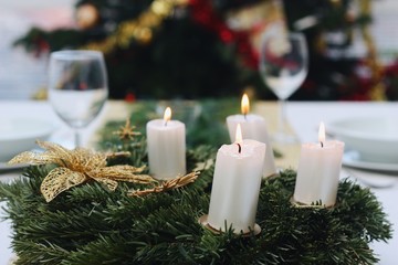 Obraz na płótnie Canvas Christmas wreath with four white candles lit