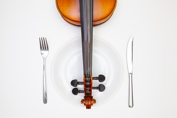 White plate and old violin on the white  wooden table.