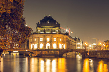 Fototapeta na wymiar Museum Island at night in the center of Berlin. autumn mood on the river spree with bridges. Light reflects in the water from the river. historic buildings are illuminated.