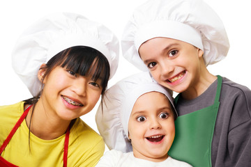 funny happy china girl and caucasian childs  with  chef  hats in kitchen