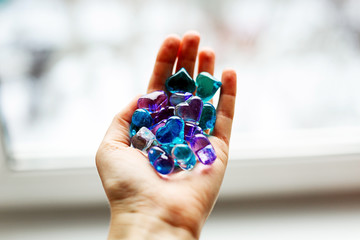 Some small colorful plastic hearts in a hand on daylight. Symbol of love and care.