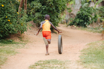 Child playing with a tire in Uganda, Africa