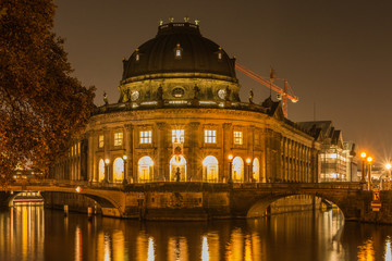 Fototapeta premium Museum Island at night in the center of Berlin. autumn mood on the river spree with bridges. Light reflects in the water from the river. Historic buildings in the foreground