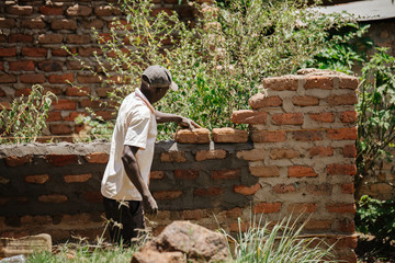 man building a house in Uganda, Africa