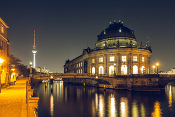 Berlin at night. Museum island with the river Spree. over the spree are bridges. in the background the television tower is recognizable. on the riverbank is a lighted path.