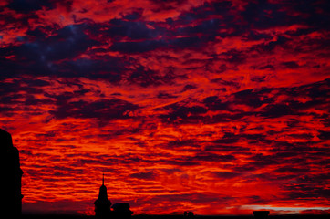 Fototapeta na wymiar red bloody sunset in cloudy sky above the village. beautiful countryside landscape - poland, szczecin