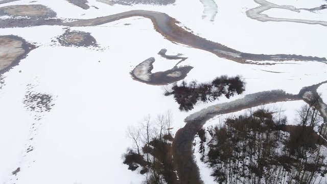 Aerial fly oy shot of large cracks in iced over lake in Canada