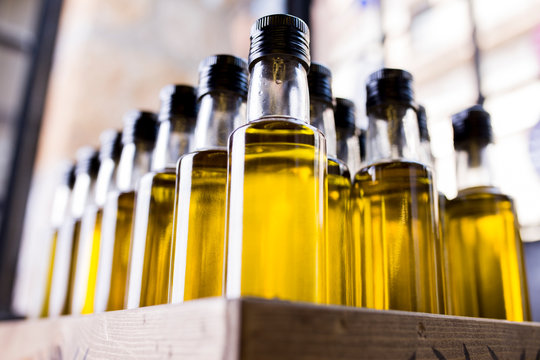olive oil bottles in wooden crate. blurred background 