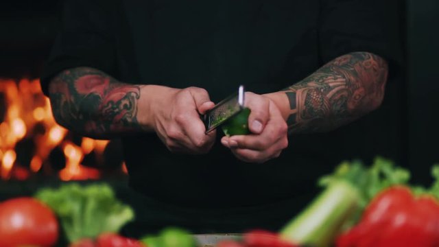 Close up of restaurant chef rubbing a lime peel on a grater in a restaurant kitchen cut fruit hand vegetarian organic preparation cooking food fresh citric slow motion