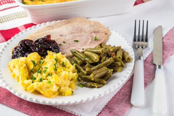 Meal plate for holiday with smoked pieces of turkey and two sides.