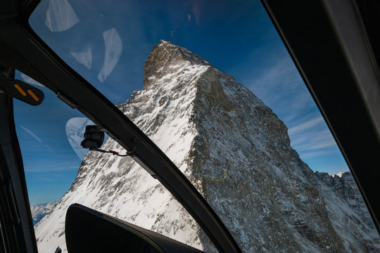 Aerial View Of Majestic Matterhorn Mountain From Inside A Helicopter In Front Of A Blue Sky.