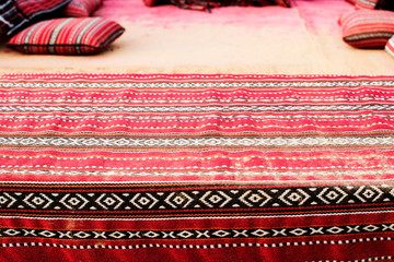 Decorative pattern in the style of arabesque on a carpet in the desert with pillows