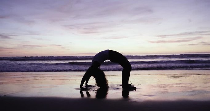 yoga practice on the beach- Very flexible girl backbend bridge pose