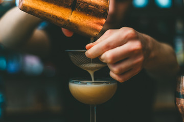 The process of preparing a cocktail. The barman is preparing an alcoholic beverage.