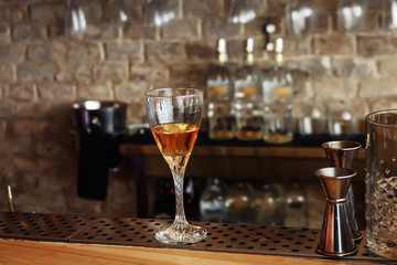 Alcohol,taste and drink concept-glasses with whiskey,old glass barrel on stone table and wooden background.