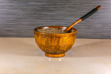 Chia seeds and wooden spoon inside a wooden bowl