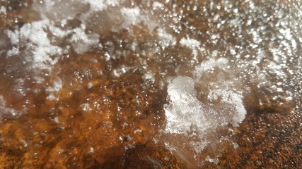 snow melting into water under sunlight on road under sunlight