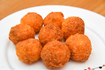 Cheese balls, Breaded mozzarella cheese balls with tomato in white dish on wood blackground