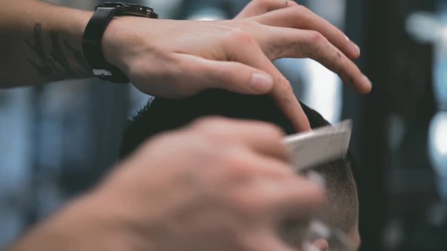 Men's haircut in barbershop. Scissor cutting. Macro shooting.