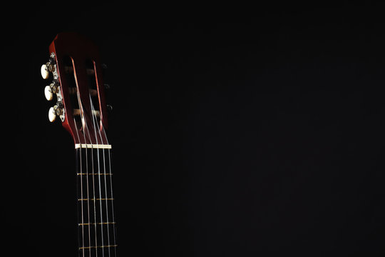 Acoustic guitar on black background, closeup. Space for text