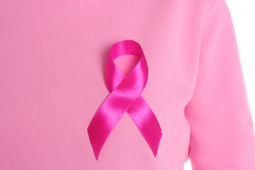 Woman with pink ribbon on white background, closeup. Breast cancer awareness