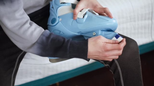 Boy is Sharpening his figured skates manually, ice-skating shoe preparing