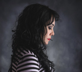 Brunette woman in profile with striped shirt