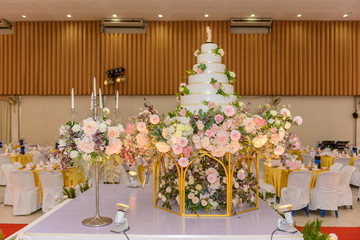 wedding cake with Decorated with flowers and Candlestick at marriage ceremony