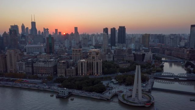 China Shanghai Aerial v47 Hyperlapse flying low over Huangpu river with waterfront view with sun setting in backdrop 10/18