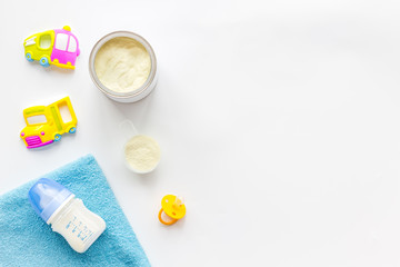 Handmade toys for newborn baby. Rattle. Feeding bottle with milk. White background top view mockup