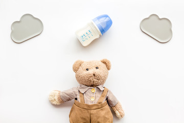 Craft toys for kids. Handmade teddy bear and baby bottle with milk. White background top view