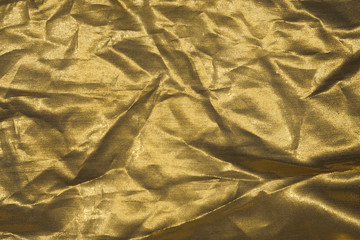 Luxury gold textile background. Silk cloth texture. Fabric pattern.