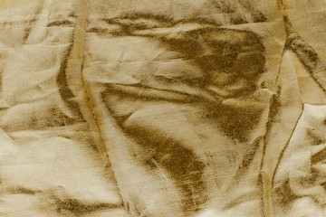 Luxury gold textile background. Silk cloth texture. Fabric pattern.